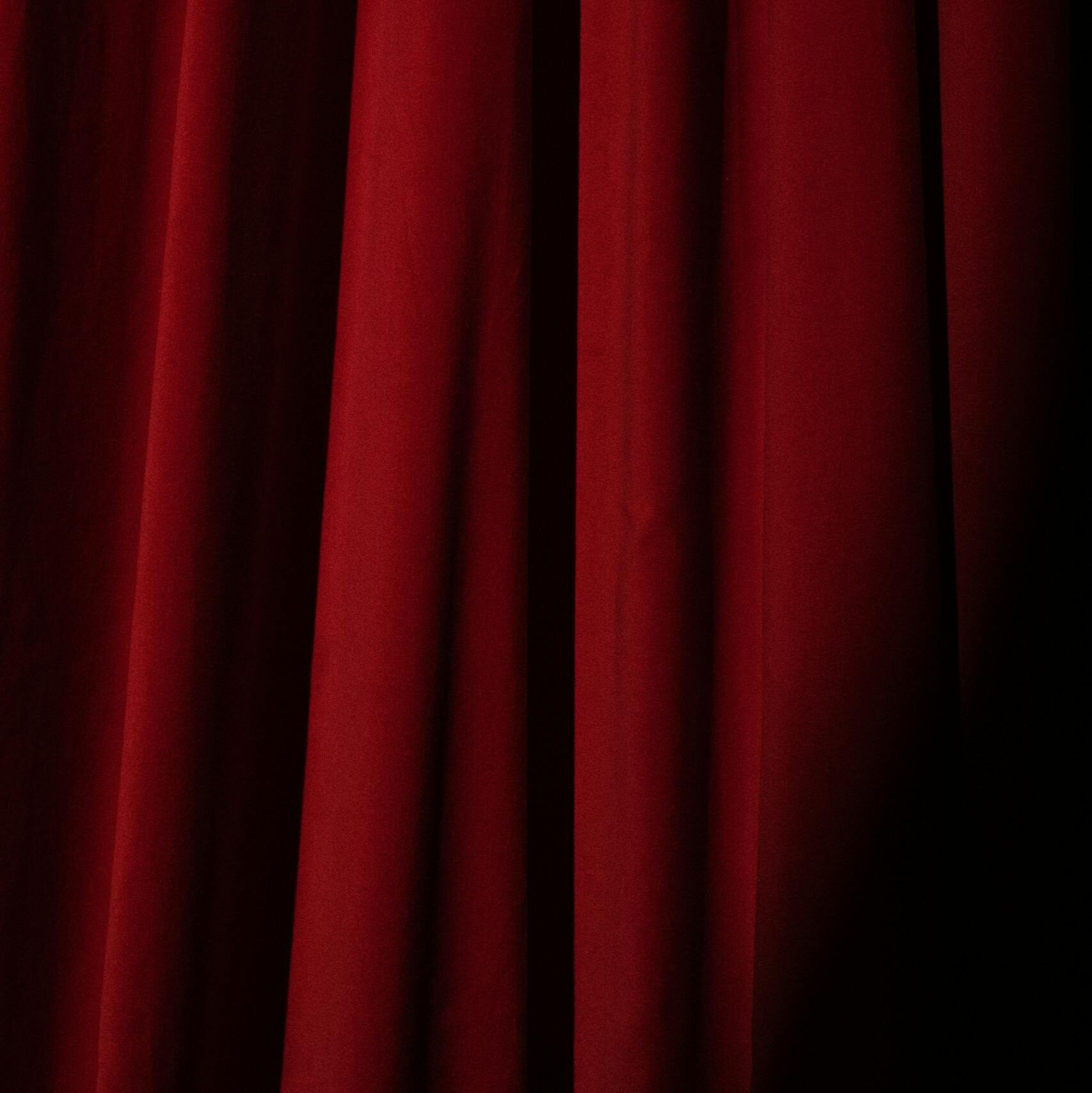 Deep red velvet theater curtain, perfect for presentations or artistic backgrounds.